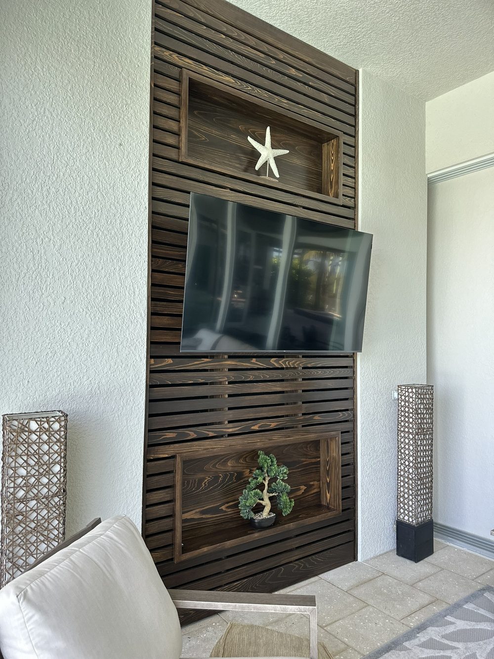 Custom wood slat accent wall with built-in display niches and mounted TV