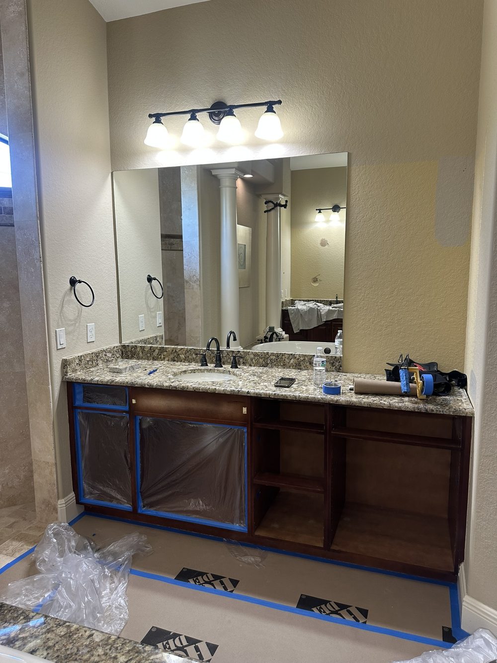 Bathroom vanity before cabinet painting — dark cherry wood cabinets with granite counter