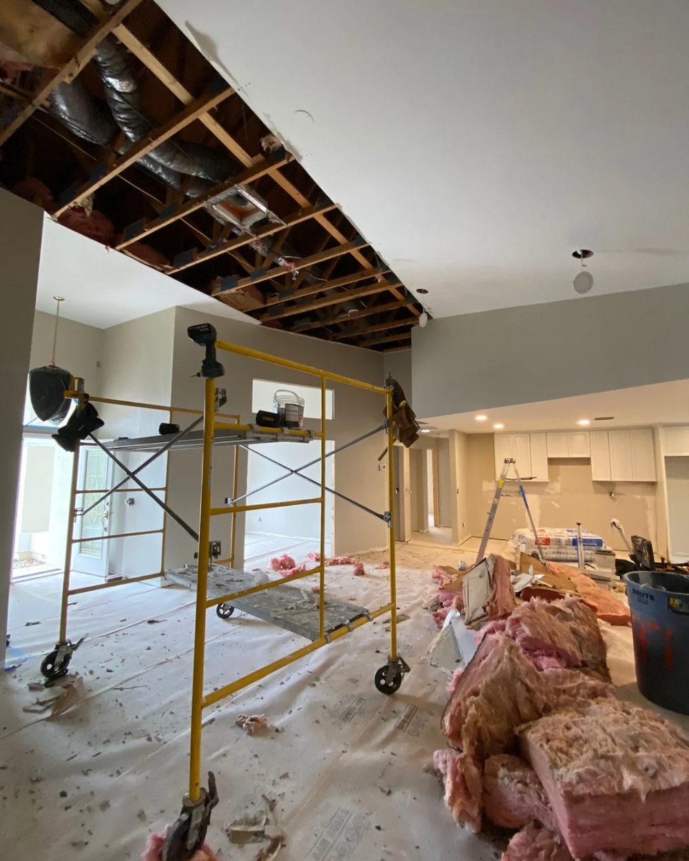 Ceiling before drywall repair — exposed framing and insulation after water damage