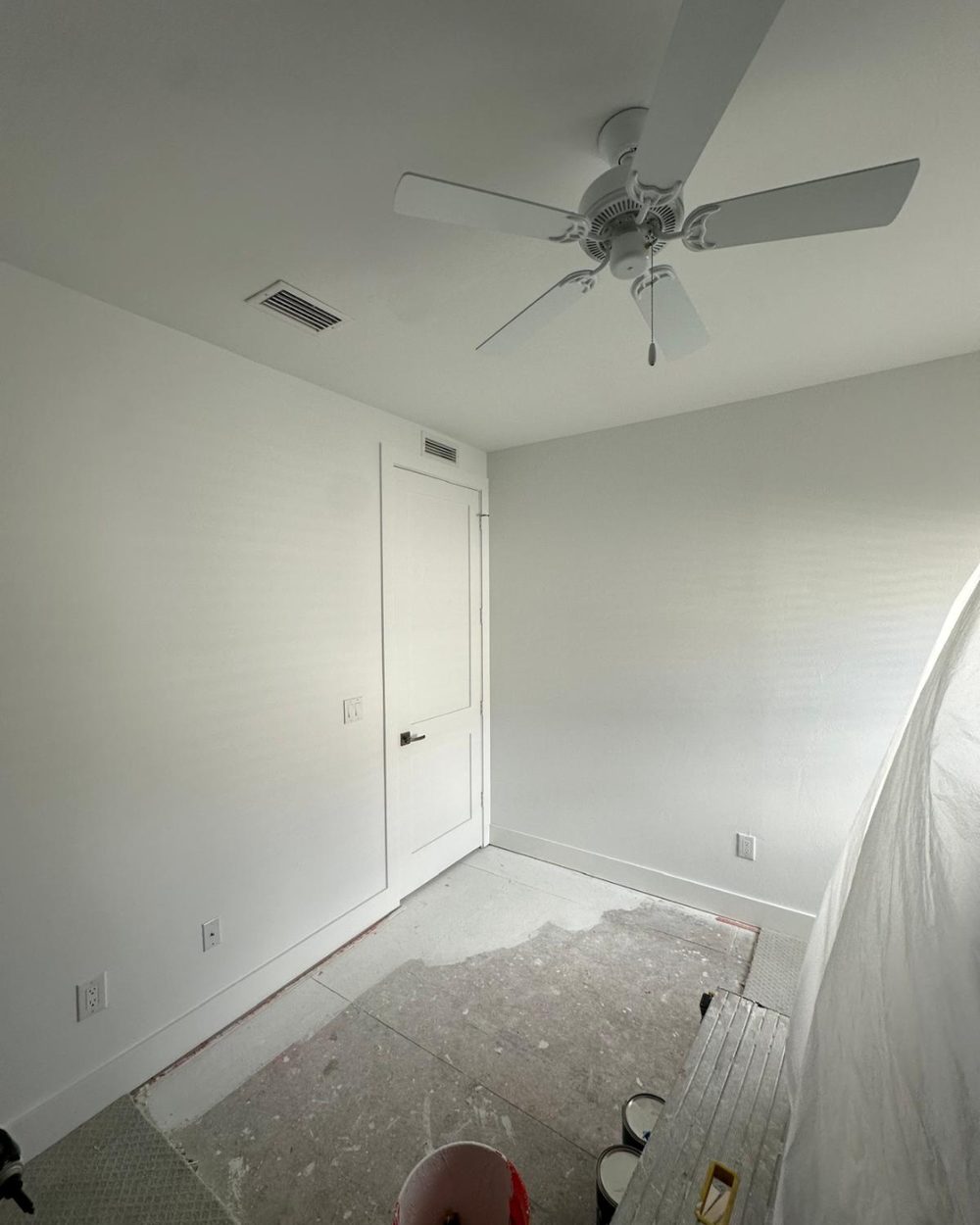 Bedroom after restoration — walls rebuilt, painted, and ceiling fan reinstalled