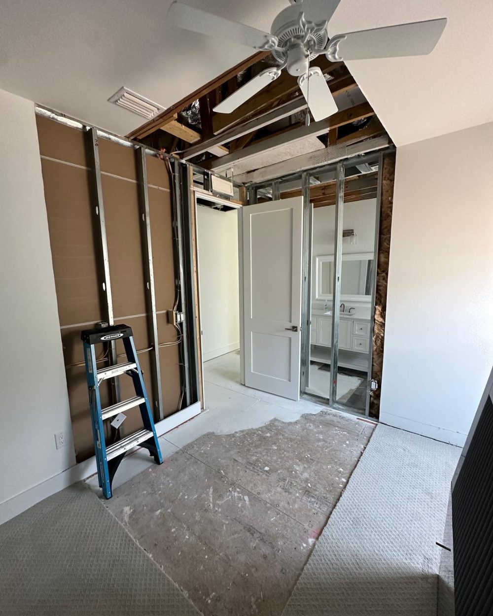 Bedroom before restoration — gutted to studs and subfloor after water damage